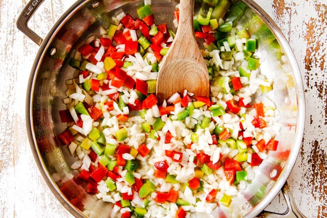 showing how to make King Ranch Casserole by cooking onions and bell peppers in a stainless steel skillet