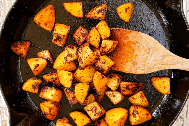 showing how to make steak and potatoes recipe by searing potatoes in a cast iron skillet