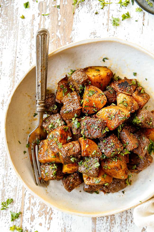 showing how to garnish steak and potatoes by chopping a plate with fresh parsley