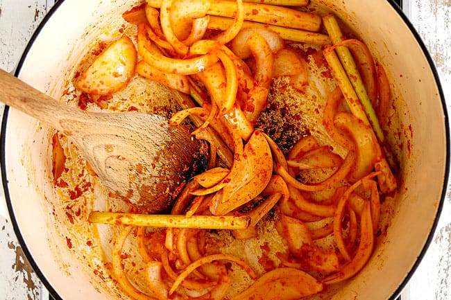 showing how to make Thai Tom Yum Soup by sautรฉing the lemongrass, onions, galangal, and ginger in a white Dutch oven