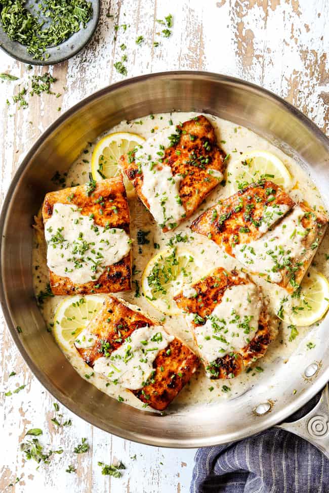 top view of mahi mahi in a stainless steel pan with lemon sauce
