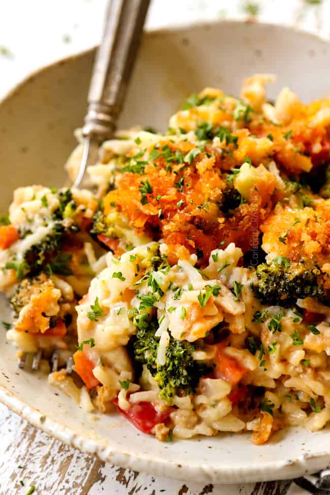 a plate of chicken broccoli cheese rice casserole with a silver fork