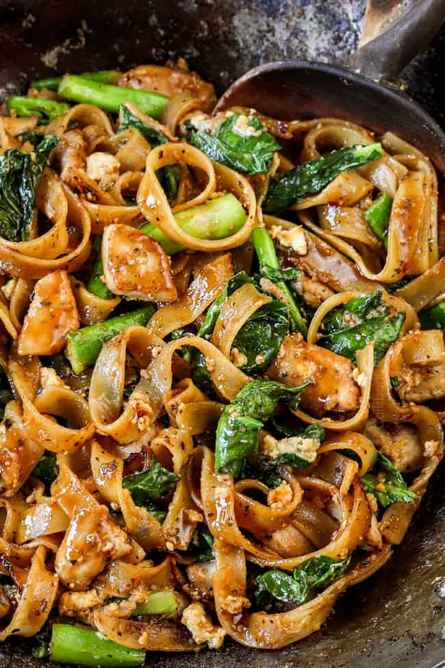 up close of pad see ew noodles in wok smothered in sauce