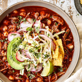 showing how to garnish pozole soup with a top view of pozole soup with cabbage, radishes, cilantro, red onions