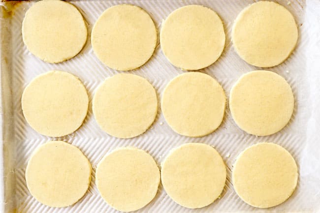 showing how to make sopes recipe by transferring flattened sopes to a parchment paper lined baking sheet
