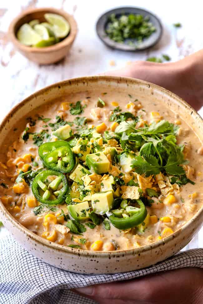 two hands holding a bowl of best white chicken chili recipe