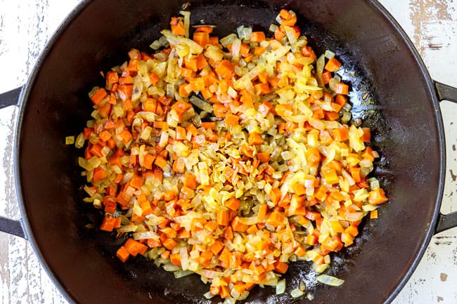 showing how to make lentil curry recipe by cooking onions and carrots in a black pot