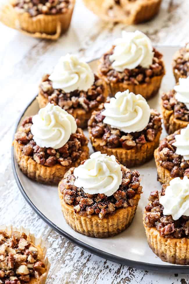 mini pumpkin cheesecakes with whipped cream on a platter