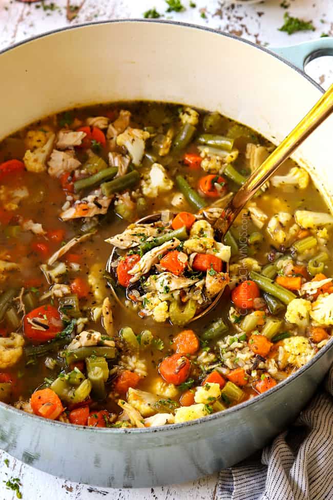 a ladle spooning turkey soup recipe in a big Dutch oven