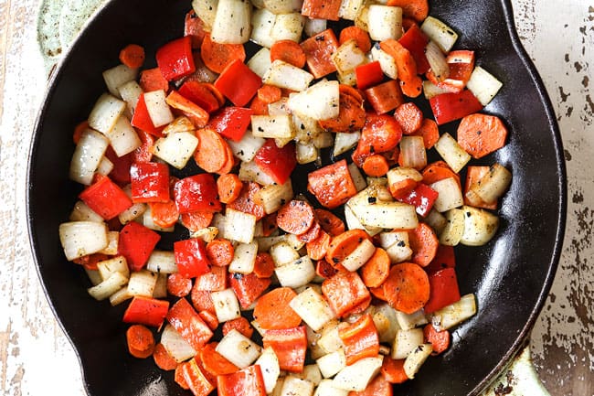 showing how to make shrimp stir fry recipe by stir frying onions, carrots and bell peppers