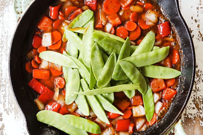 showing how to make shrimp stir fry recipe by adding snow peas and stir fry sauce