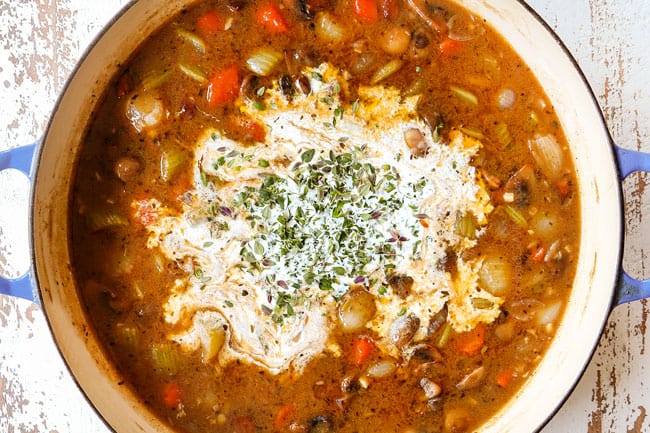 showing how to make chicken fricassee recipe by adding heavy cream, parsley and thyme leaves