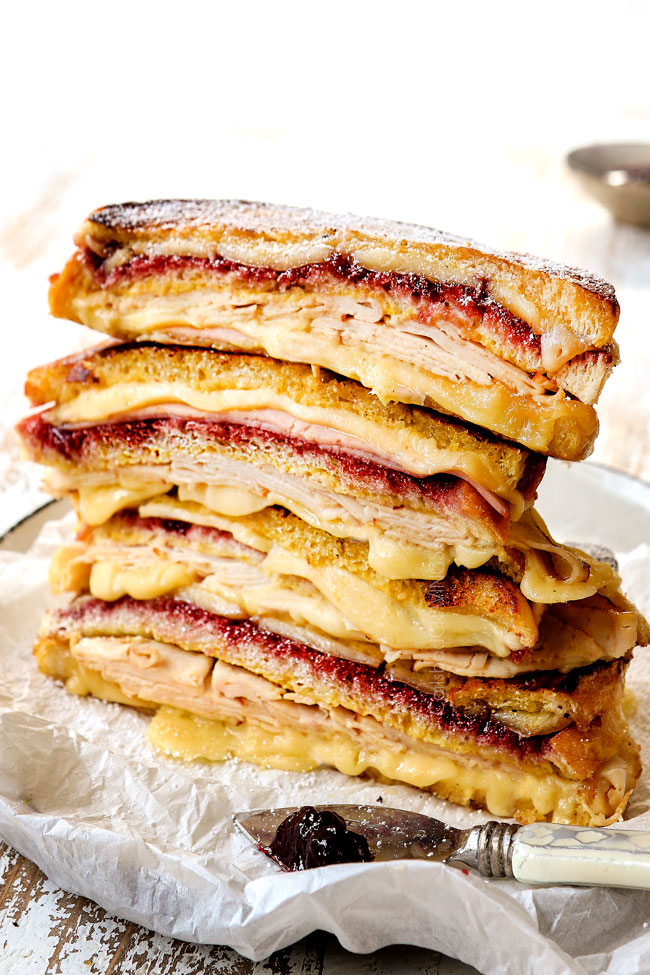 a stack of sliced Monte Cristo sandwiches with ham, turkey, Swiss cheese