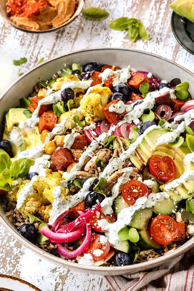 side view of rice bowl with chicken vegetables and cliantro yogurt sauce