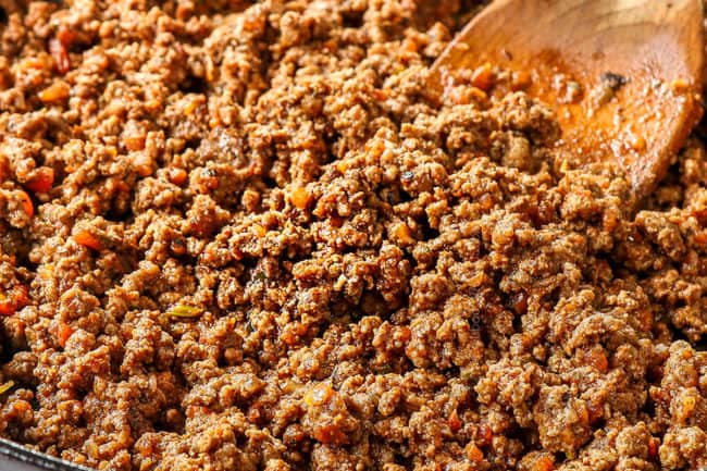 showing how to make taco bowl recipe by browning taco meat in a skillet