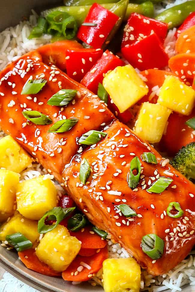 up close of teriyaki glazed salmon garnished with green onions and sesame seeds