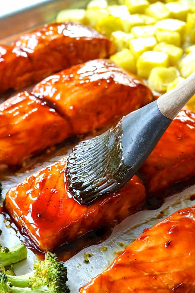 showing how to make teriyaki salmon recipe by glazing baked salmon with teriyaki glaze