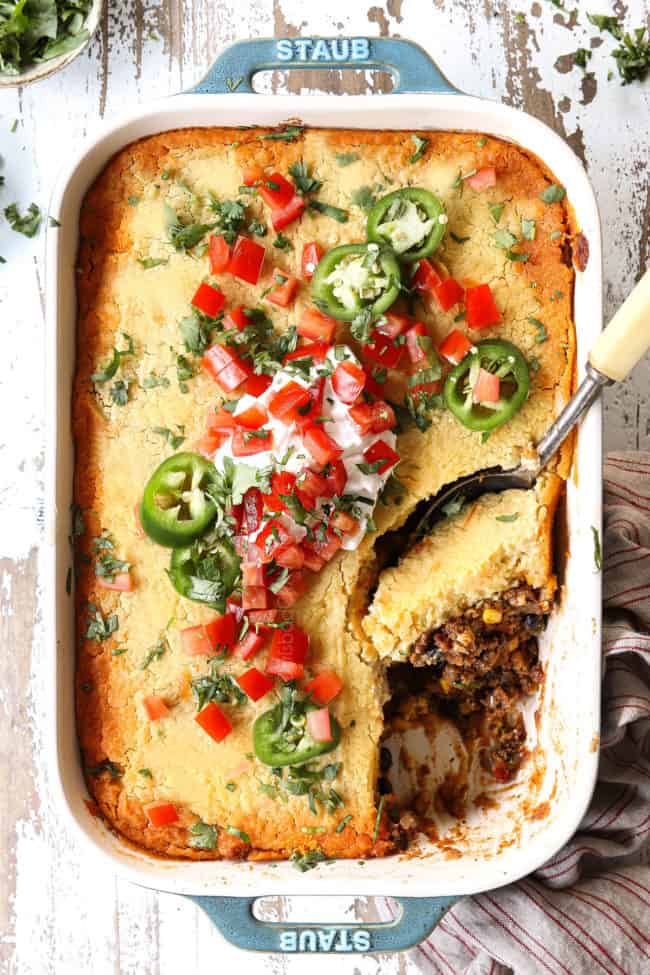 top view of tamale pie topped with sour cream, tomatoes, and jalapenos
