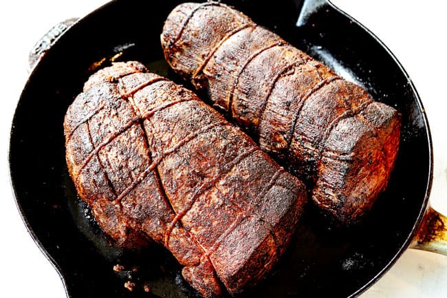showing how to cook beef tenderloin by searing beef tenderloin roasts on all sides in a cast iron skillet