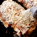 showing how to cook beef tenderloin by slathering with herb butter before the beef goes in the oven
