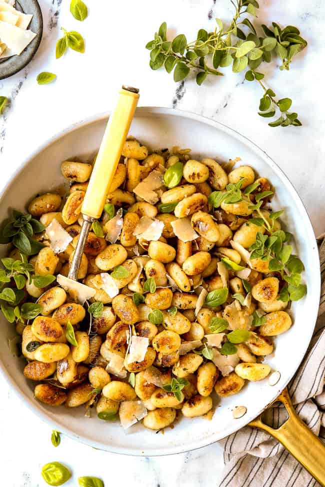 showing how to make gnocchi recipe by tossing gnocchi with sauce in a skillet until combined