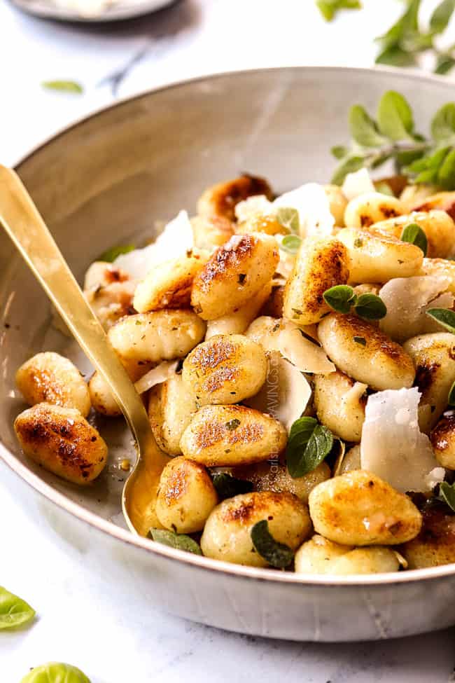 showing how to serve gnocchi sauce recipe by garnishing with shaved Parmesan