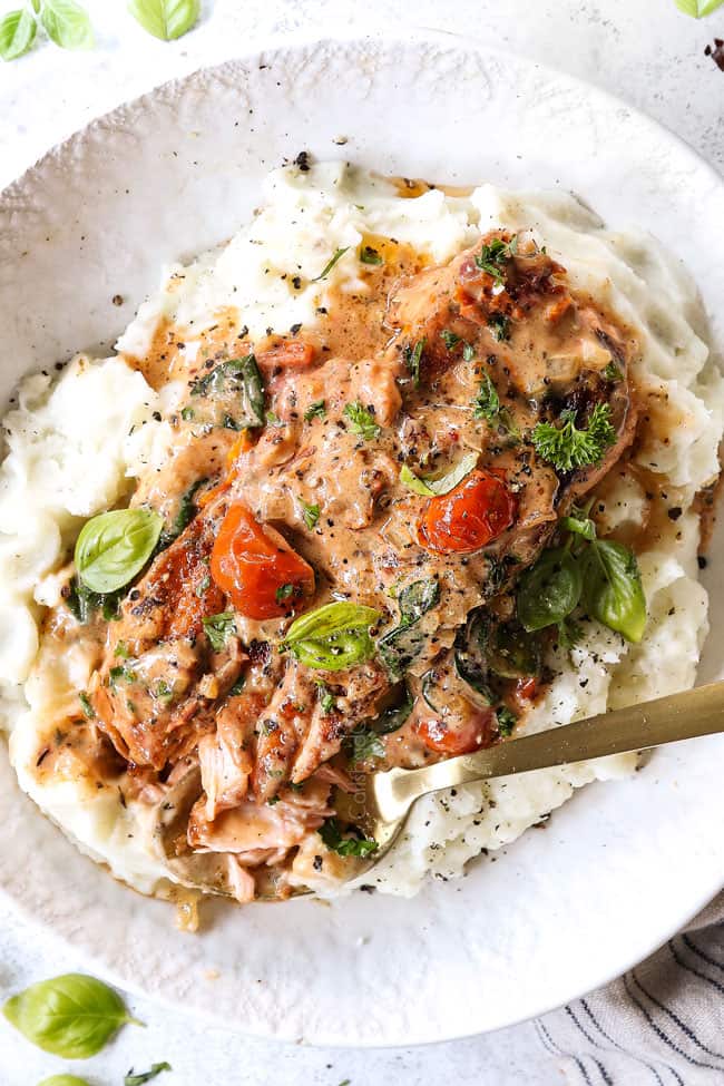 showing how to serve Tuscan salmon recipe by serving on a bed of mashed potatoes