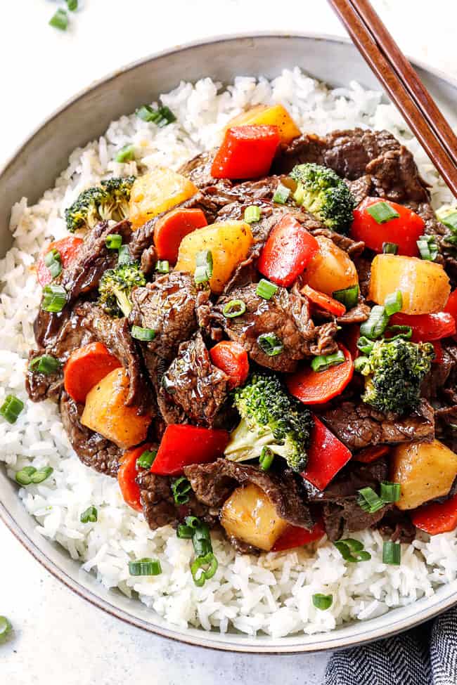 up close of beef teriyaki in a bowl garnished with green onions