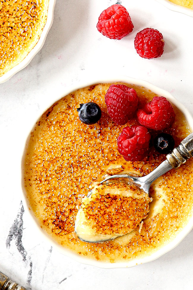 top view of best crรจme brรปlรฉe recipe with a spoon in the custard