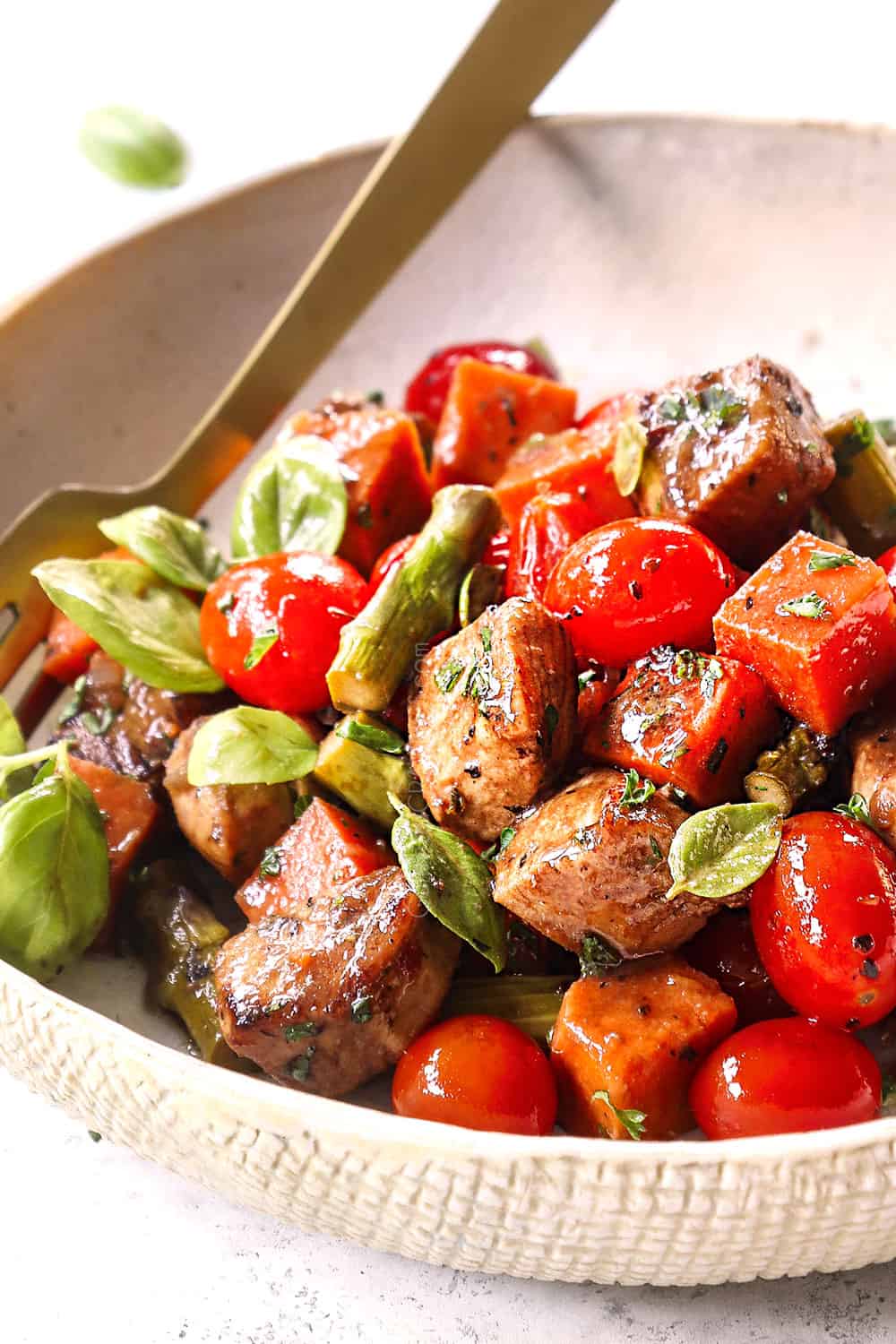 side view of balsamic chicken recipe on a plate garnished with basil