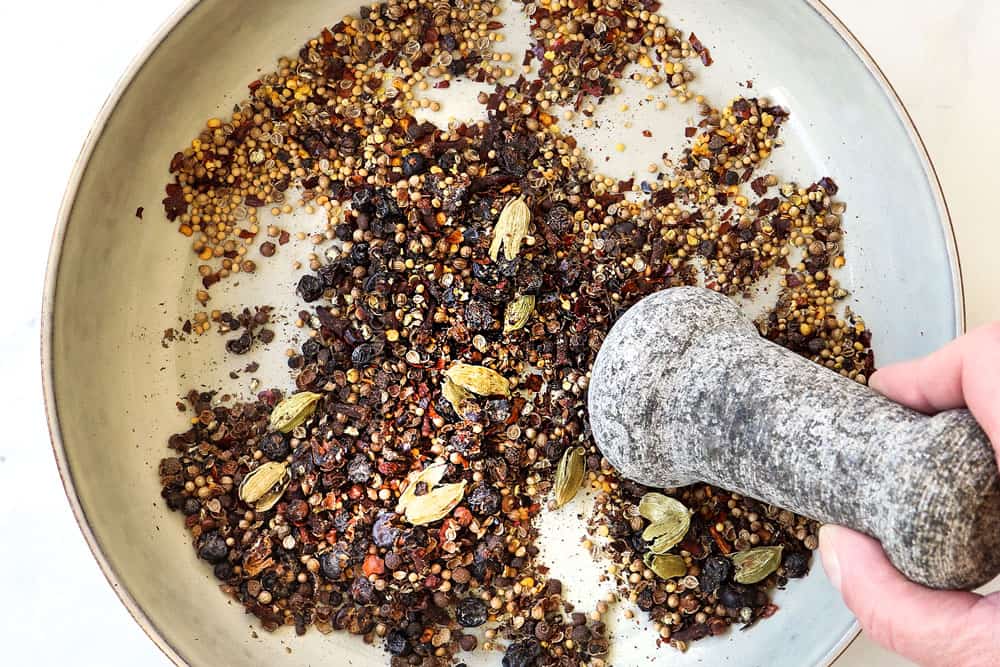 showing how to make corned beef by crushing corned beef spices with a mortar and pestle