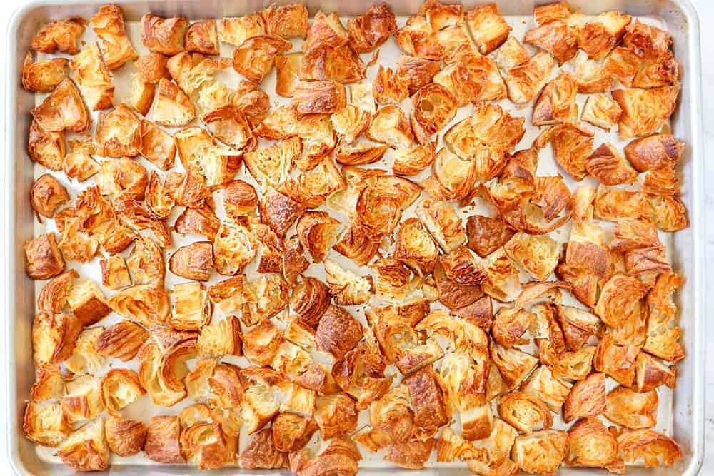 showing how to make breakfast casserole by toasting croissants on a baking dish