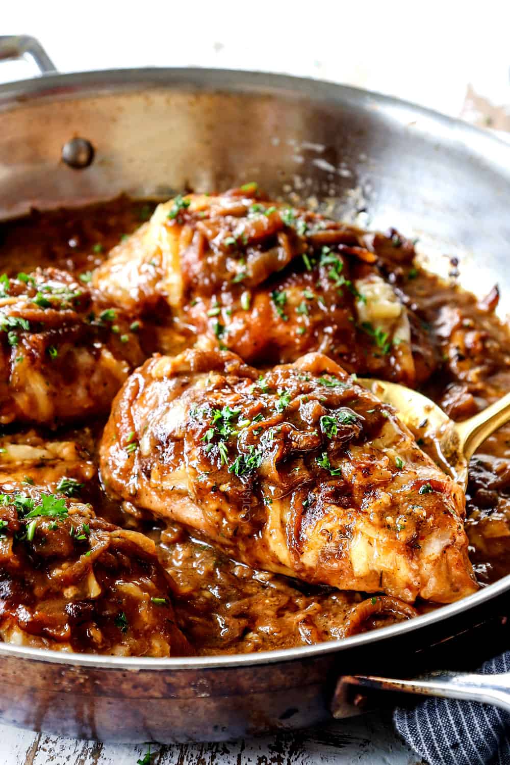a ladle picking up a piece French onion chicken
