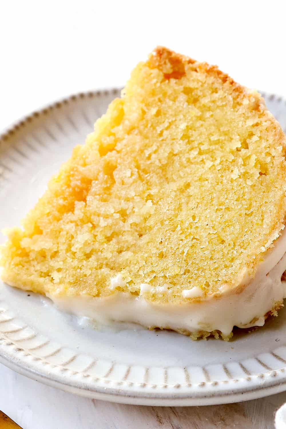 a slice of lemon pound cake laying on on a plate showing how moist it is