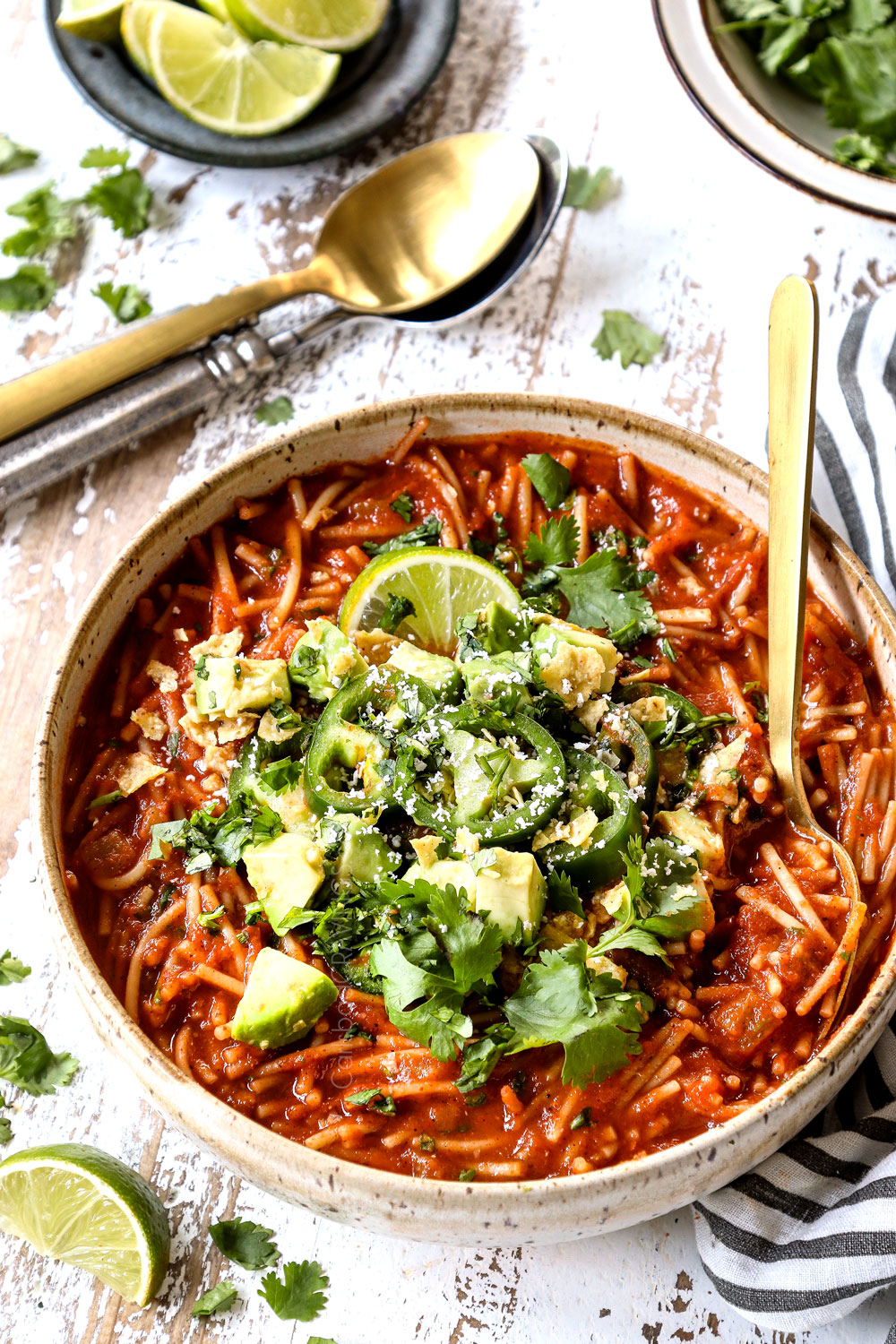 a bowl of fideo soup garnished with cilantro and chopped avocados