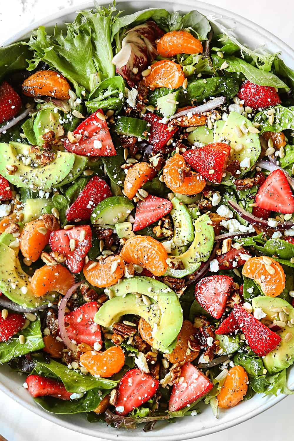 top view of spinach and strawberry salad recipe tossed in a bowl