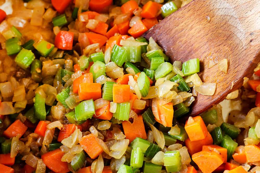 showing how to make lemon chicken orzo soup by sauteing onion, celery and carrots
