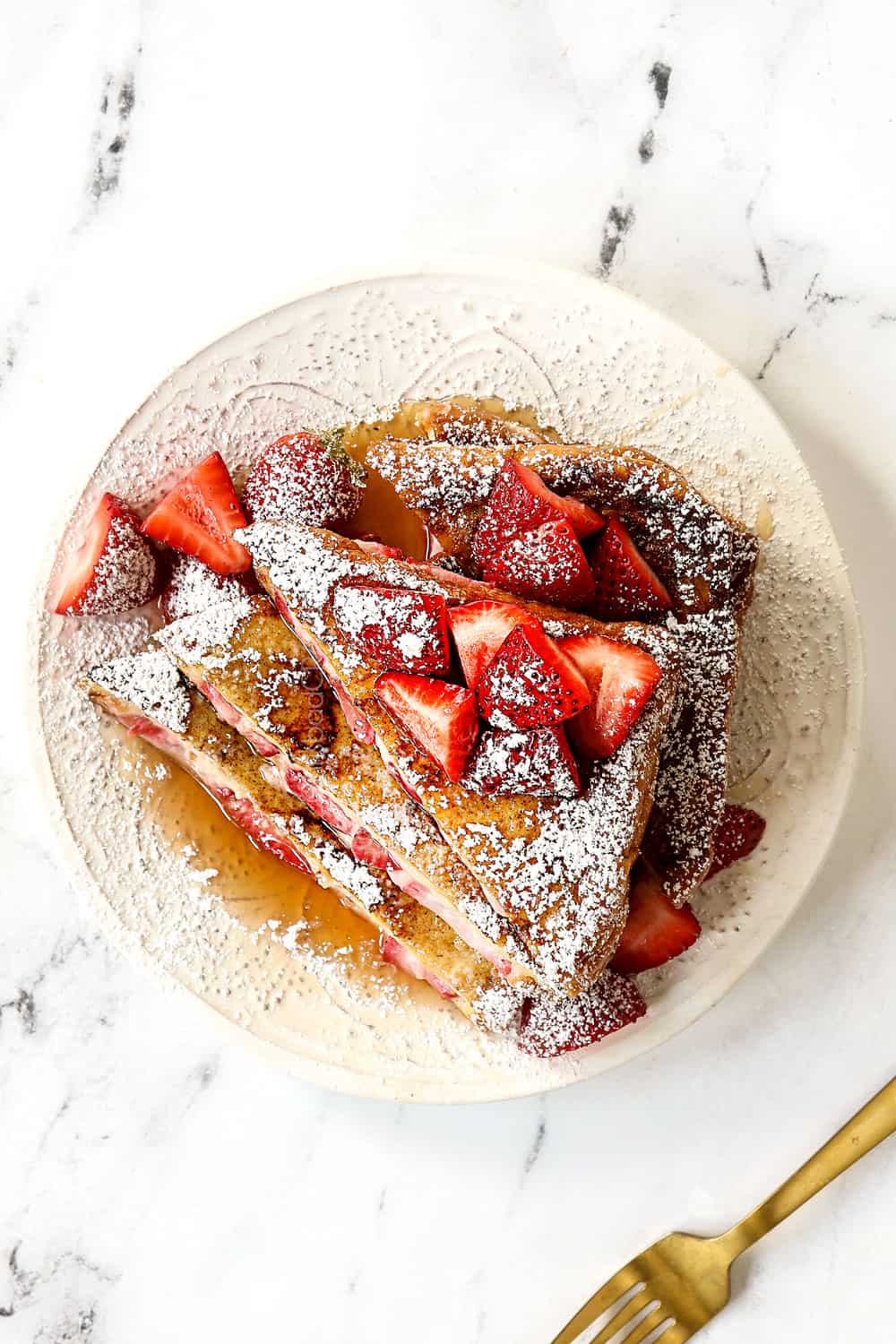 top view of stuffed French toast recipe on a white plate dusted with powdered sugar