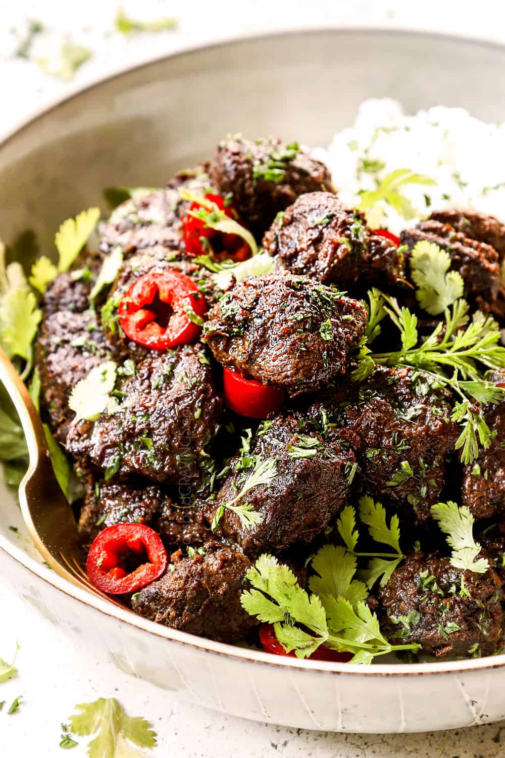 side view of beef rendang recipe in a white bowl