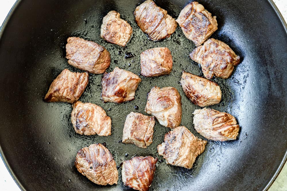 showing how to make beef rendang recipe by searing the beef in dutch oven