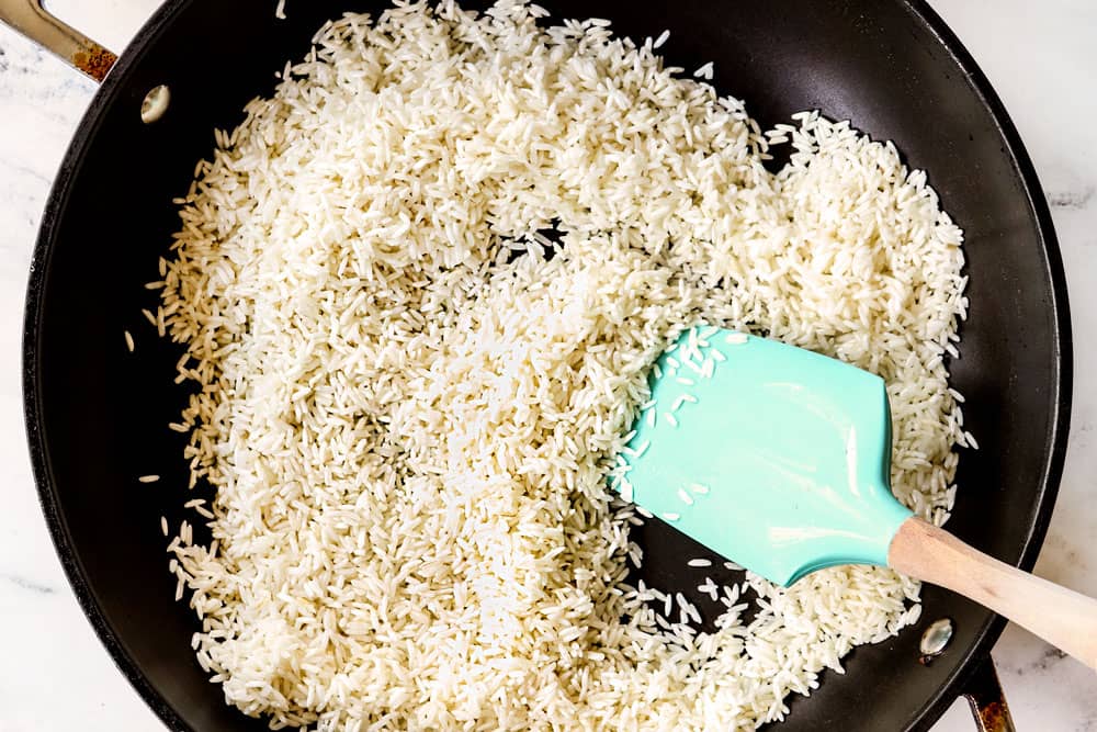 showing how to make coconut rice by toasting jasmine rice in a skillet