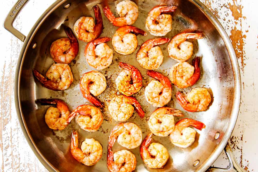 showing how to make shrimp pasta by sauteing shrimp in a stainless steel skillet