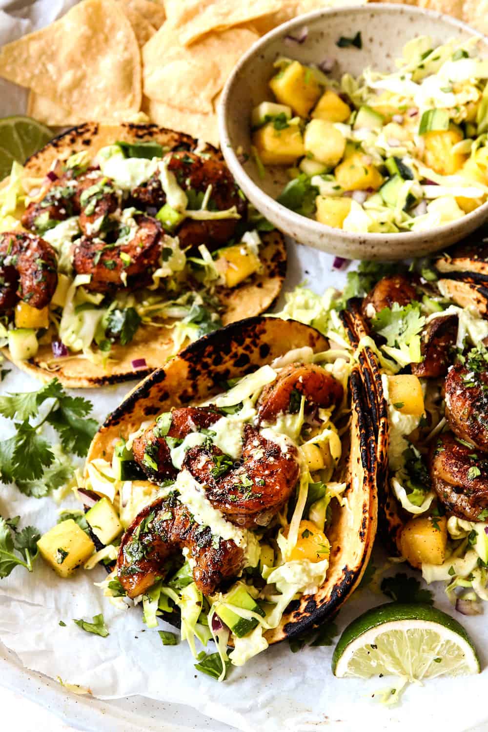 showing how to make shrimp taco recipe by drizzling with avocado crema