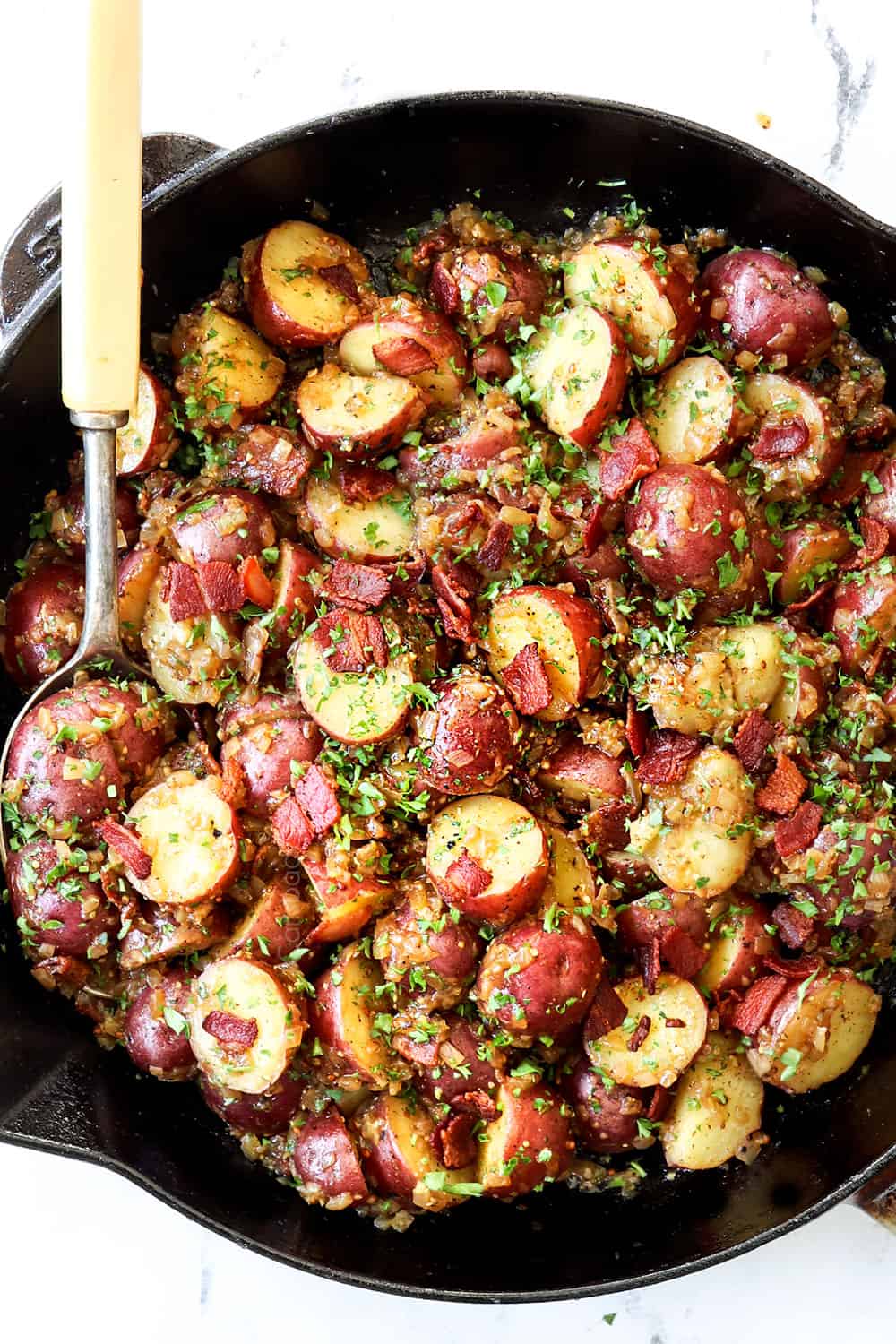 top view of German potato salad recipe in a cast iron skillet