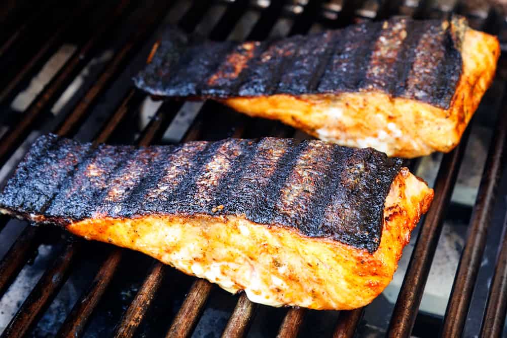 showing how to grill salmon by flipping salmon over so it's skin side up