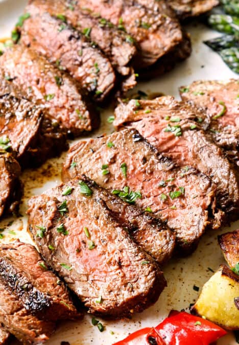 up close of sliced grilled steak lined on a platter showing what temp to cook it