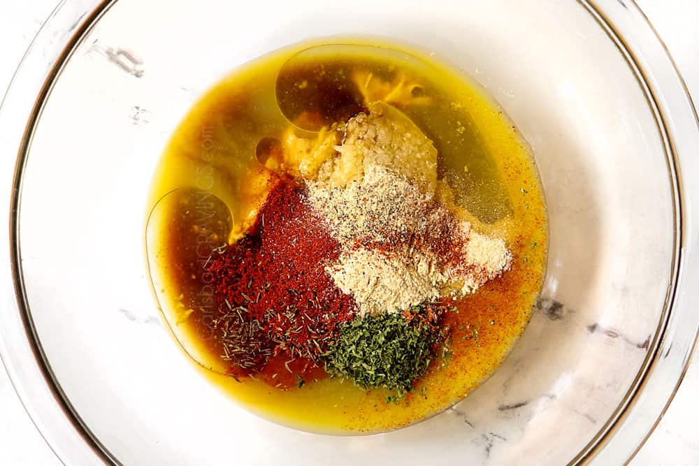 showing how to make grilled salmon in foil by adding marinade ingredients to a bowl