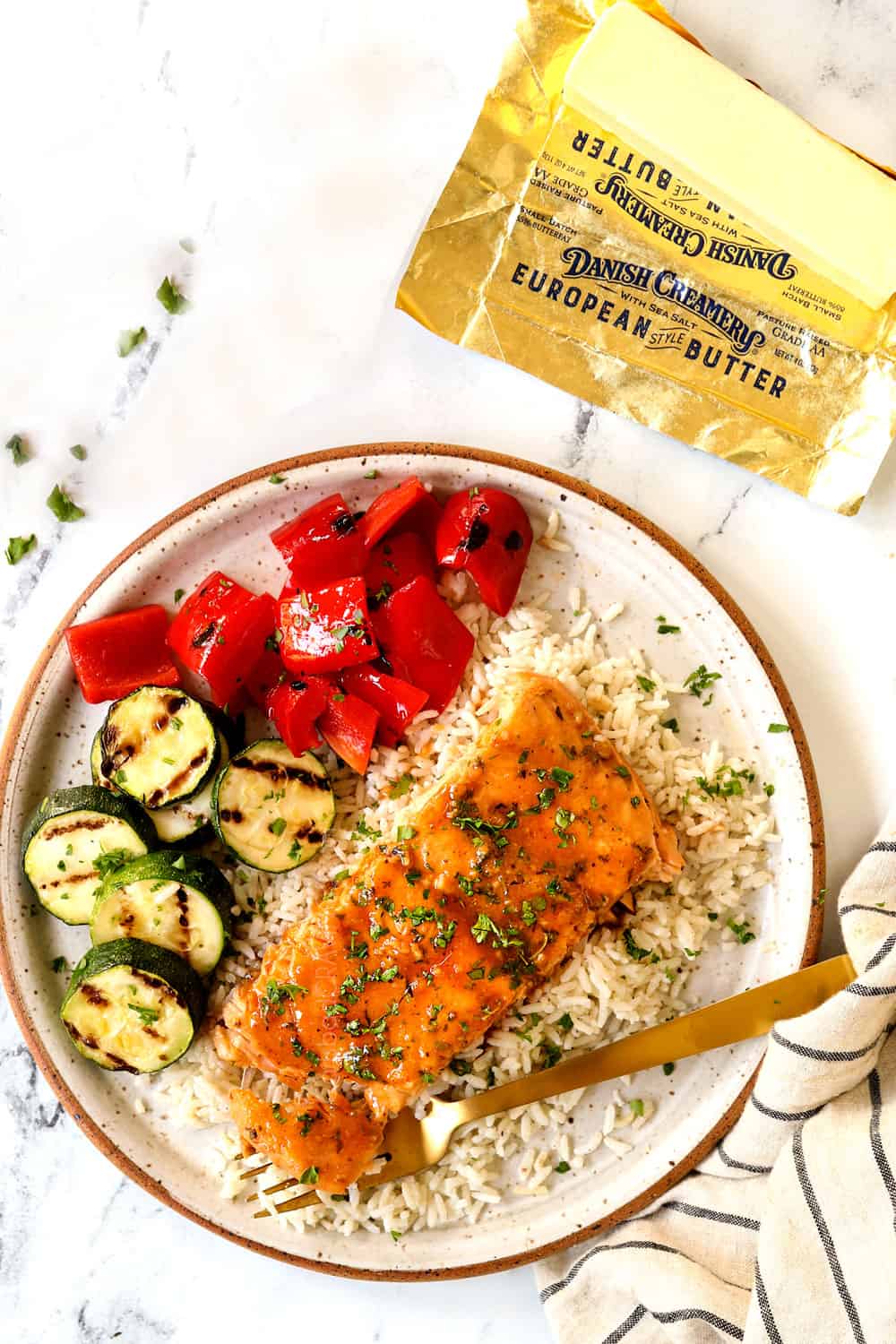 grilled salmon in foil on a plate with rice and vegetables