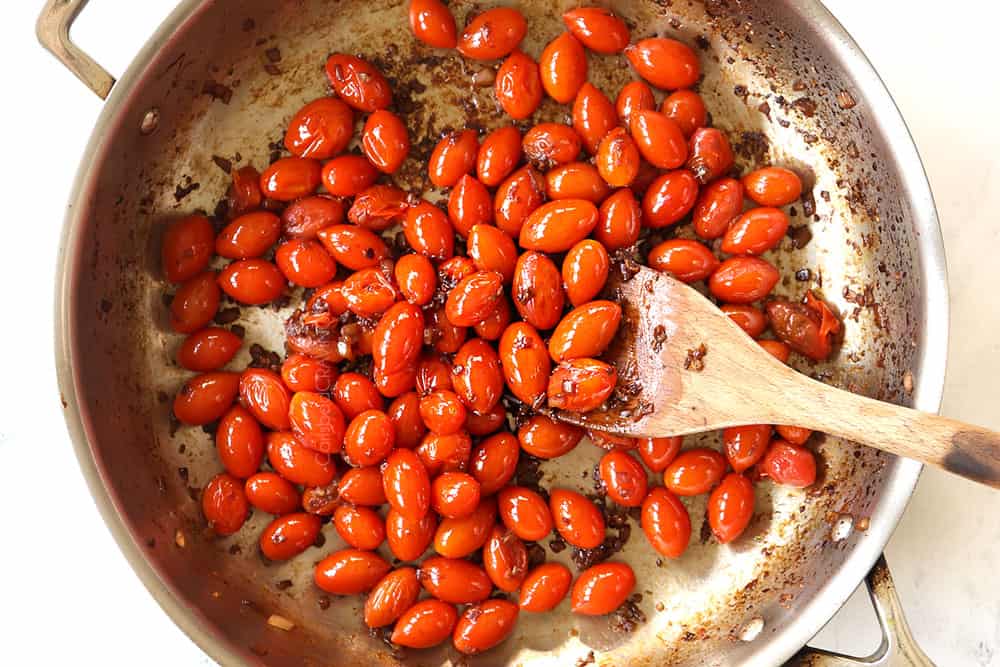 showing how to make bruschetta chicken pasta recipe by cooking tomatoes, onions and garlic in a stainless steel skillet