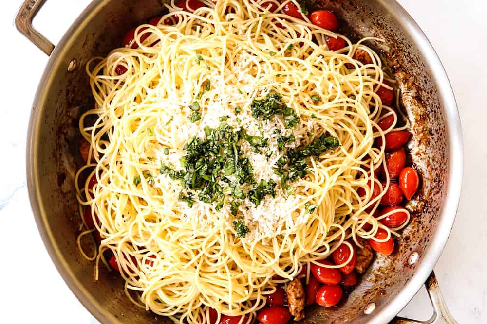 showing how to make bruschetta chicken pasta by adding pasta, parmesan and basil to the skillet with the chicken, tomatoes, garlic and sauce